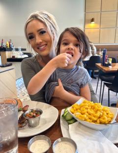 A woman and her young child eating at a restaurant.