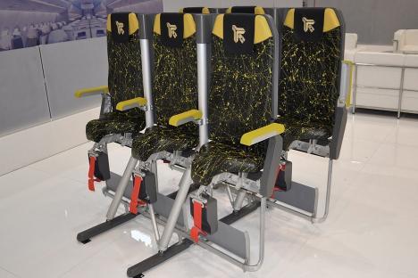 Four upright airplane seats designed to increase passenger capacity.
