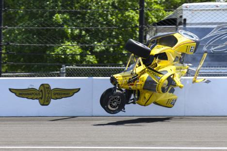 A yellow race car airborne after hitting a wall at the Indianapolis Motor Speedway.