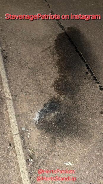 Photo of a dark stain on asphalt, possibly oil or other fluid.