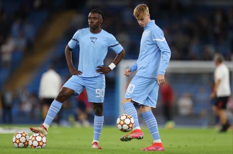 Romeo Lavia and Cole Palmer of Manchester City warming up before a Champions League match.