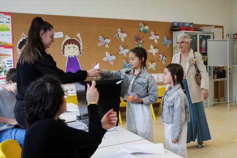 A child casts a ballot at a polling station.