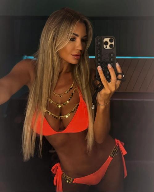 Christine McGuinness in an orange bikini, taking a selfie.