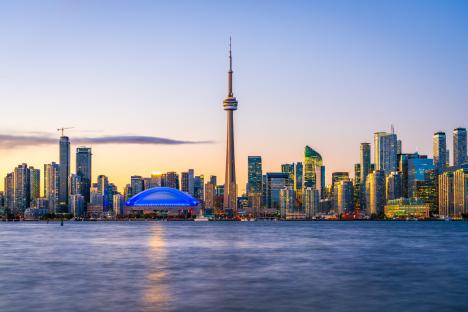 Toronto skyline at dusk over Lake Ontario.