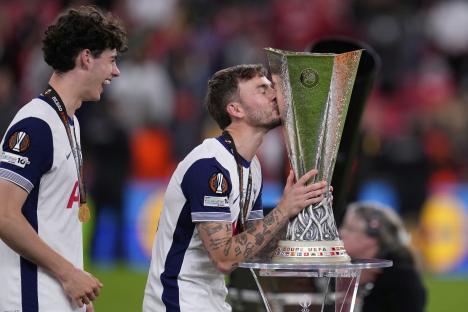 James Maddison of Tottenham Hotspur kisses the Europa League trophy.