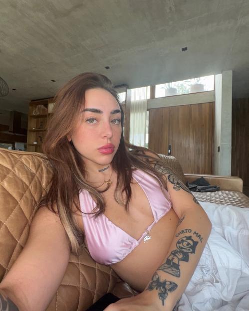 Woman in pink top sitting on a couch.