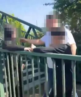 Screenshot of an altercation on a bridge, with faces blurred for privacy.