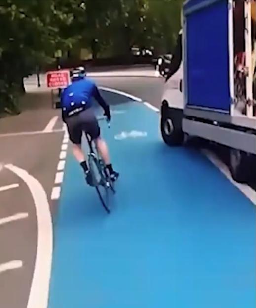 A cyclist and their bike being hit by a Tesco delivery van turning left into a bike lane.