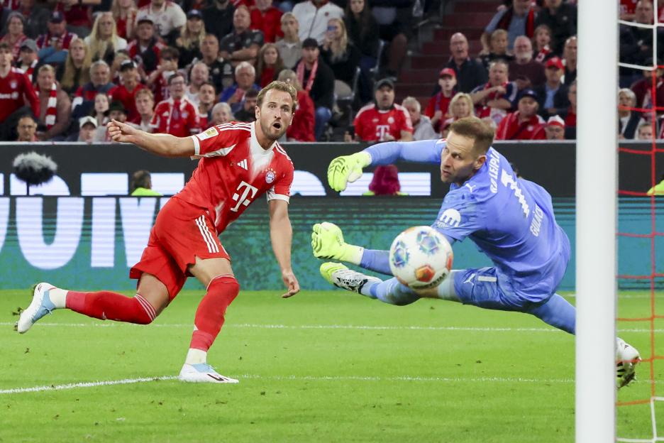 Harry Kane scoring a goal during a soccer game.