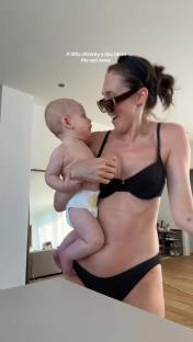 Woman holding baby, postpartum body.