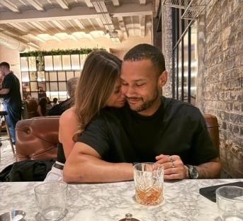 Couple embracing at a restaurant table.