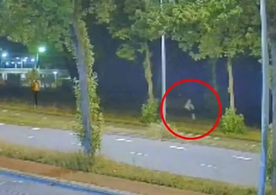 Security footage of a person running at night.