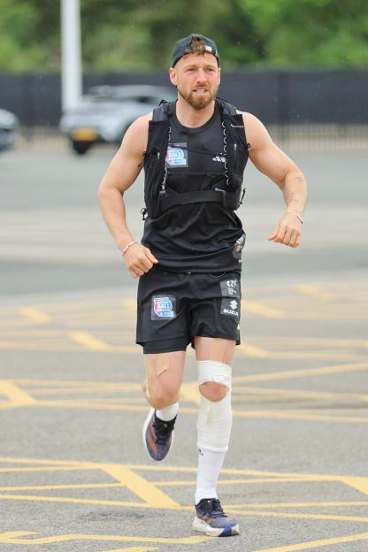Sam Thompson running, wearing a vest and shorts with Soccer Aid branding.
