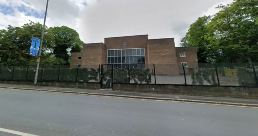 Exterior of a synagogue with a Star of David above large windows.