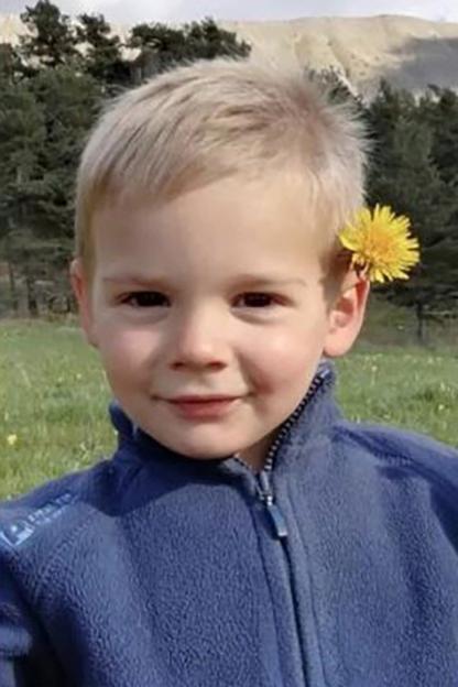 Young boy with dandelion behind his ear.