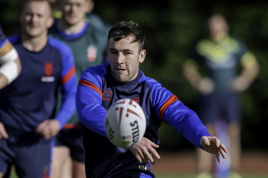 Harry Smith in an England rugby league training session, holding a Steeden rugby ball.