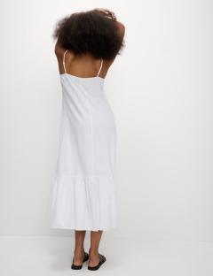 Model wearing a white linen-rich midi dress from the back.