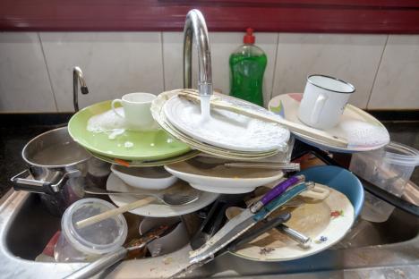 Pile of dirty dishes in a kitchen sink.