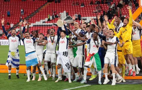 Tottenham Hotspur players celebrating a victory with a trophy.