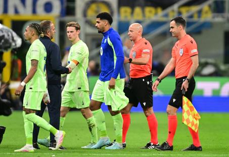 FC Barcelona coach and players speaking with referees during a soccer match.