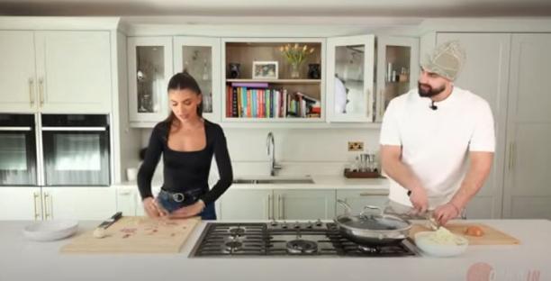 Two people cooking in a kitchen.