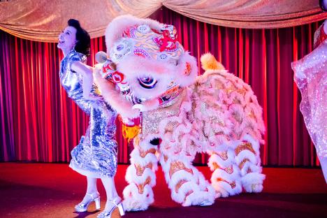 Joan Chen in a silver sequined dress with a lion dance costume.