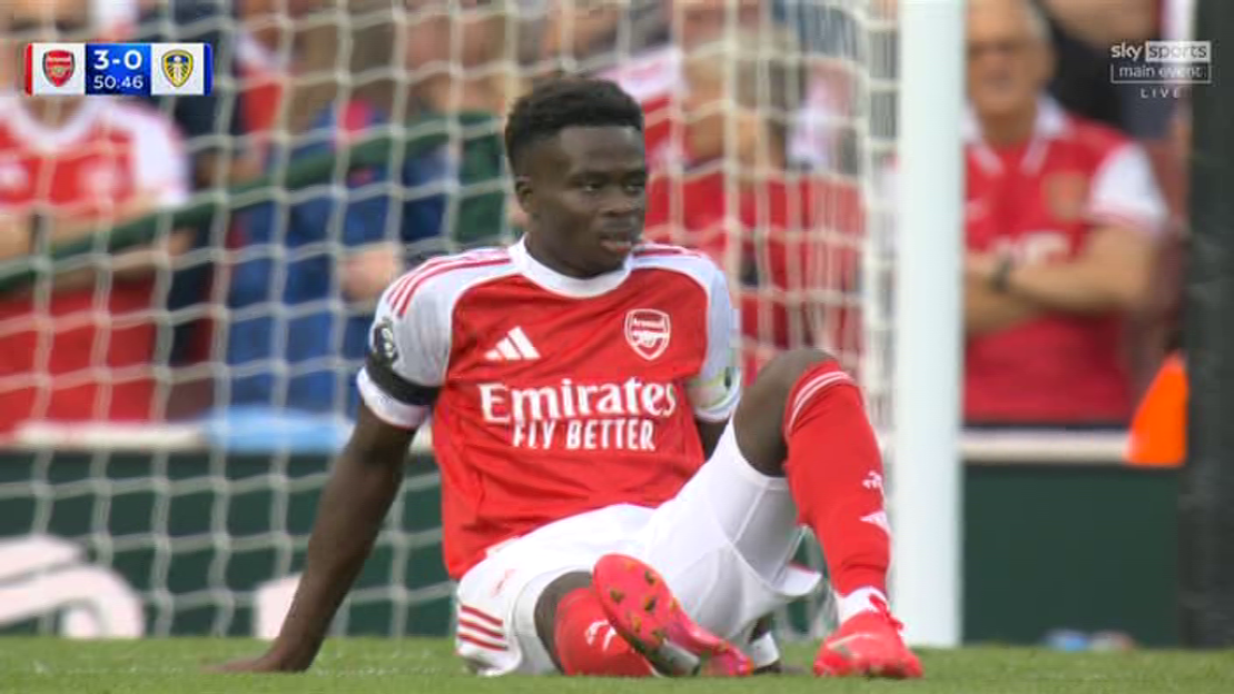Arsenal soccer player sitting on the field.