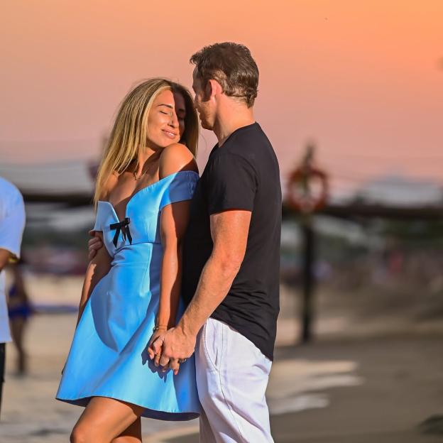 Stacey Solomon and her partner holding hands on a beach at sunset.