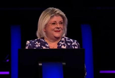 Screenshot of a woman at a podium.