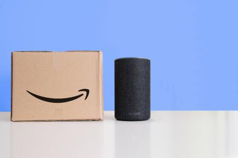 Amazon Echo smart speaker next to an Amazon package.