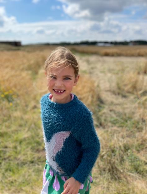 Emily, daughter of Andy Smith, in a field under a cloudy sky.