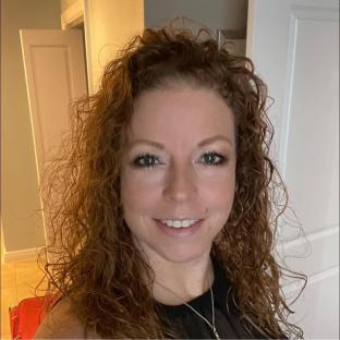 a woman with curly hair is smiling for the camera
