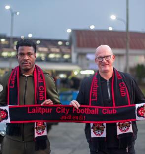 Two men holding a Lalitpur City Football Club scarf.