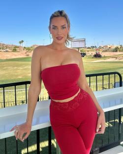 Paige Spiranac in a red outfit on a golf course.