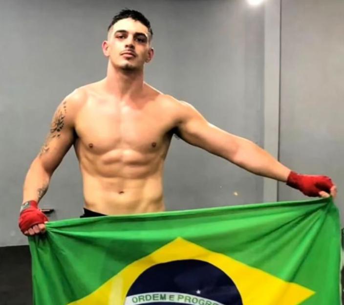 Flavio Augusto Schuller Azambuja holding a Brazilian flag.