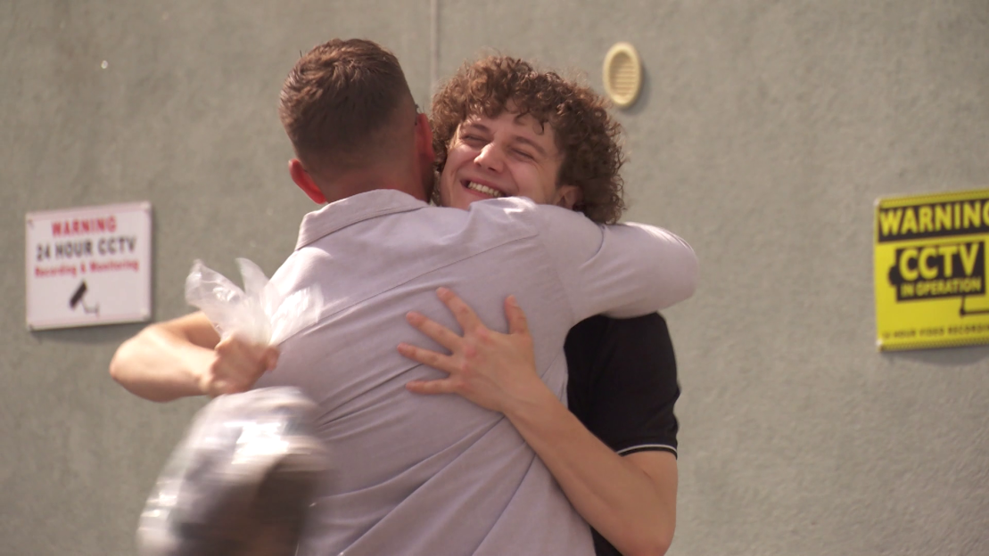 Two men embracing.