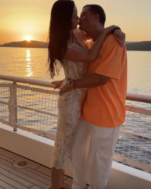 Katy Perry and Orlando Bloom kissing at sunset on a boat.