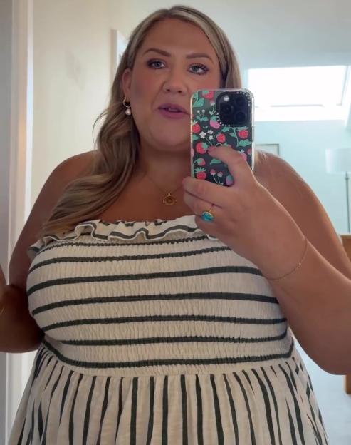 Woman in striped dress taking a selfie.