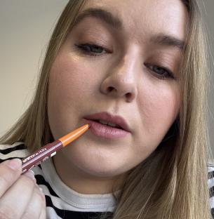 Woman applying lip liner.