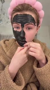 Woman removing a black face mask.