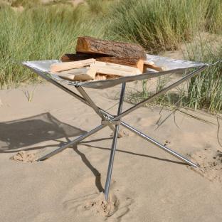 Portable mesh fire pit on a beach.