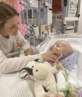 A mother comforting her toddler son in a hospital bed.