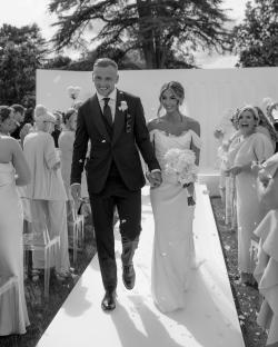Black and white photo of a bride and groom walking down the aisle after their wedding ceremony.