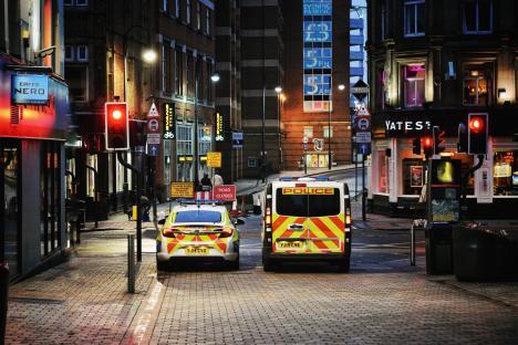Police vehicles at night on a city street.