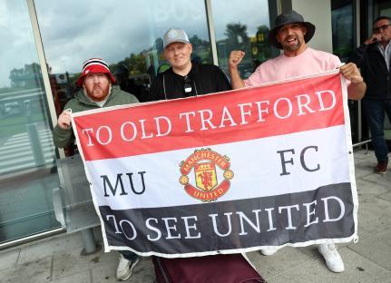 Manchester United fans holding a banner that reads