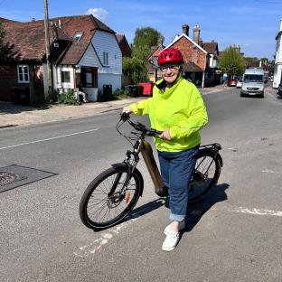 Woman standing with her e-bike on a road.