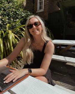 Molly Schofield working on a laptop outdoors.