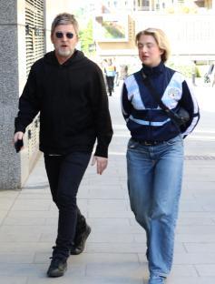 Noel Gallagher and his daughter Anais walking down a sidewalk.