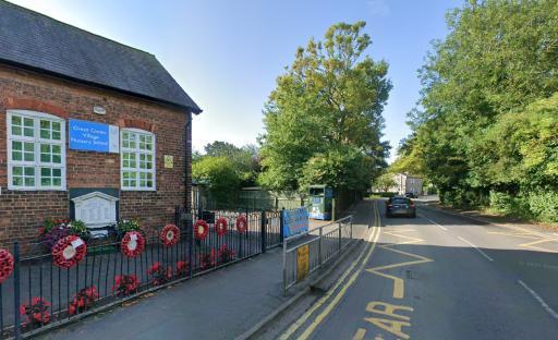 Street view of Great Coates Village Nursery School with a road and parked car.