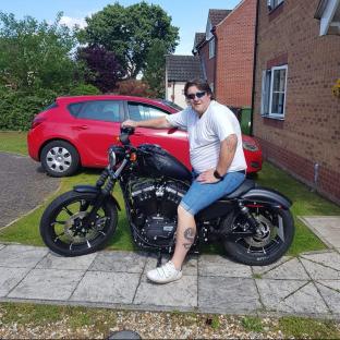 Man sitting on a Harley-Davidson motorcycle.